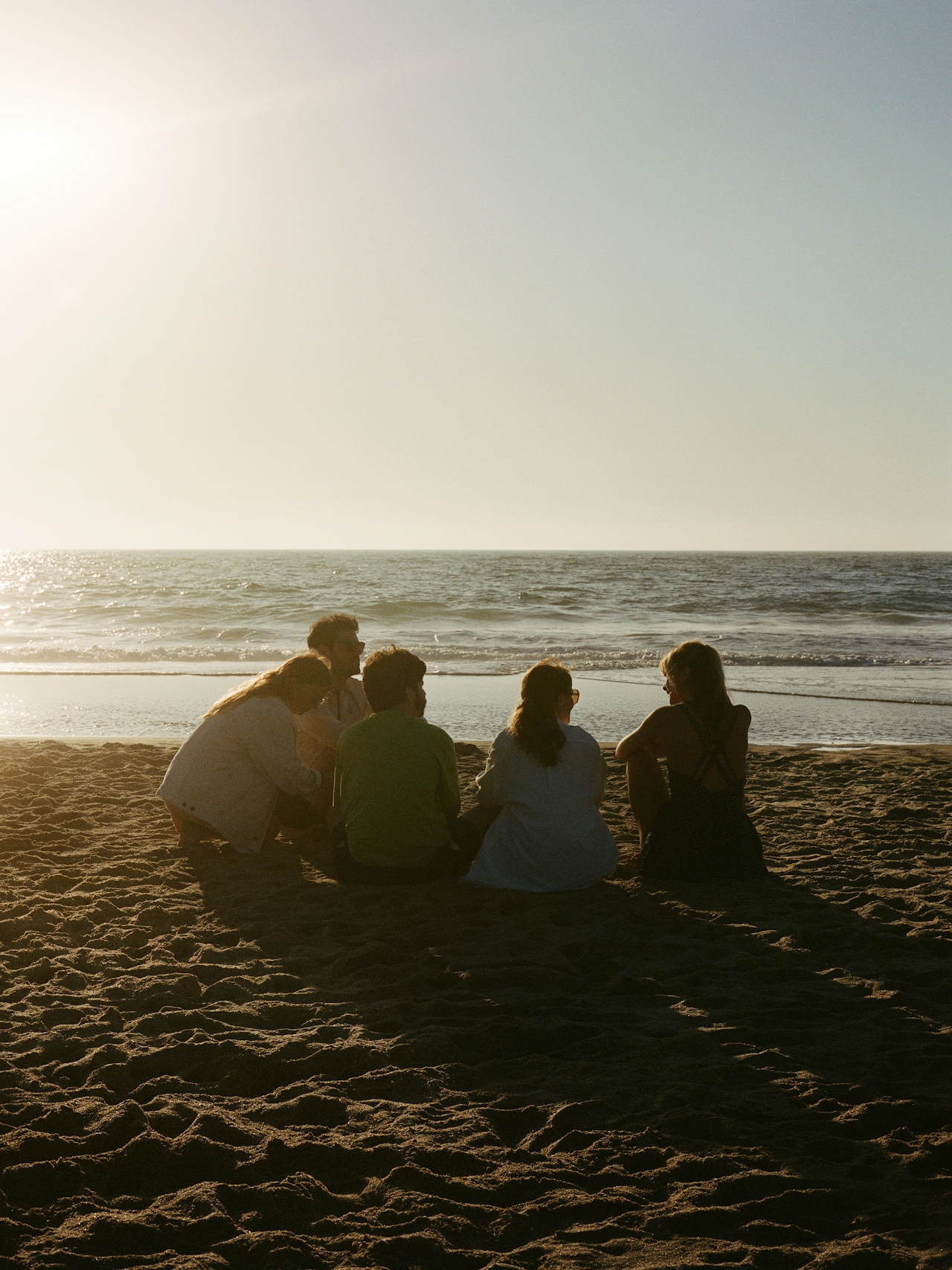 Group of travelers on the beach at golden hour